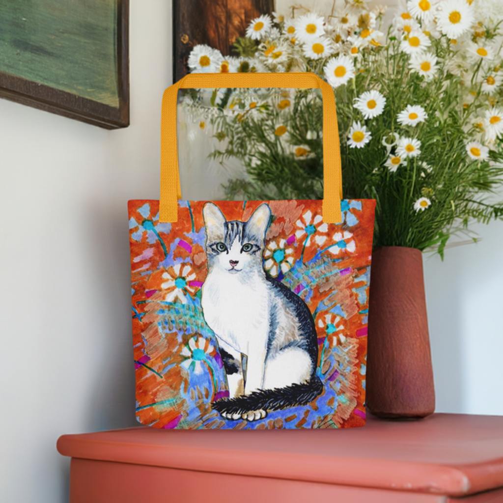 Daisy Cat Tote Bag featuring cat artwork surrounded by daisies with orange background and yellow handles