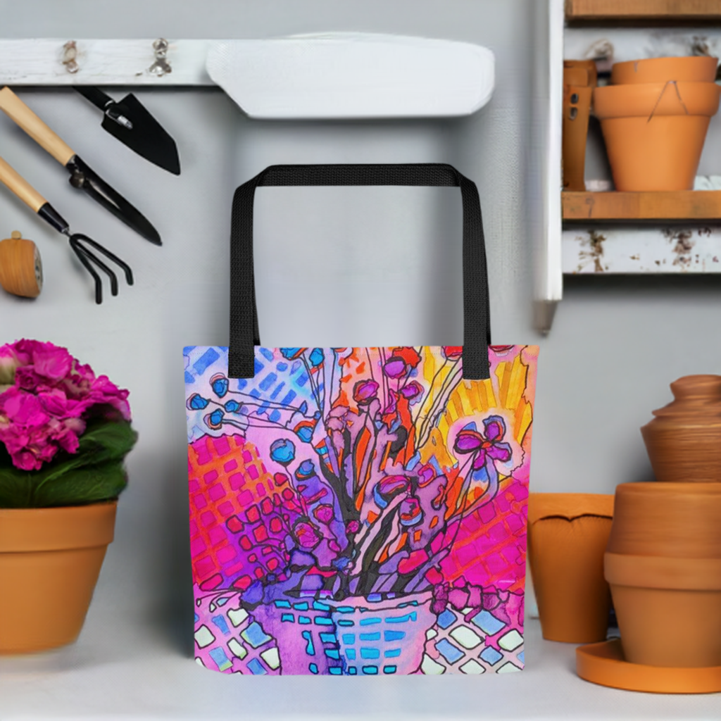 Flower Abstract Tote Bag with vibrant floral design and black handles in a gardening setting