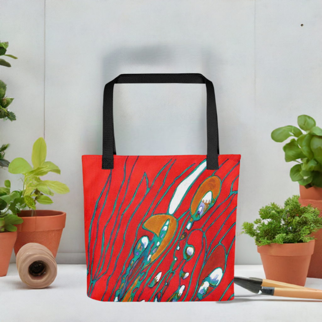 August Abstract Tote Bag with vibrant red abstract artwork by Joy Calonico and black handles displayed among potted plants