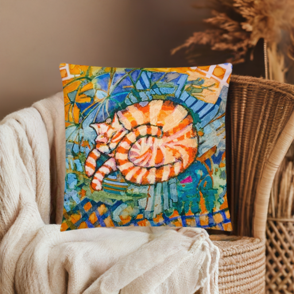 Sleeping Ginger Cat Pillow with colorful abstract art on cozy chair