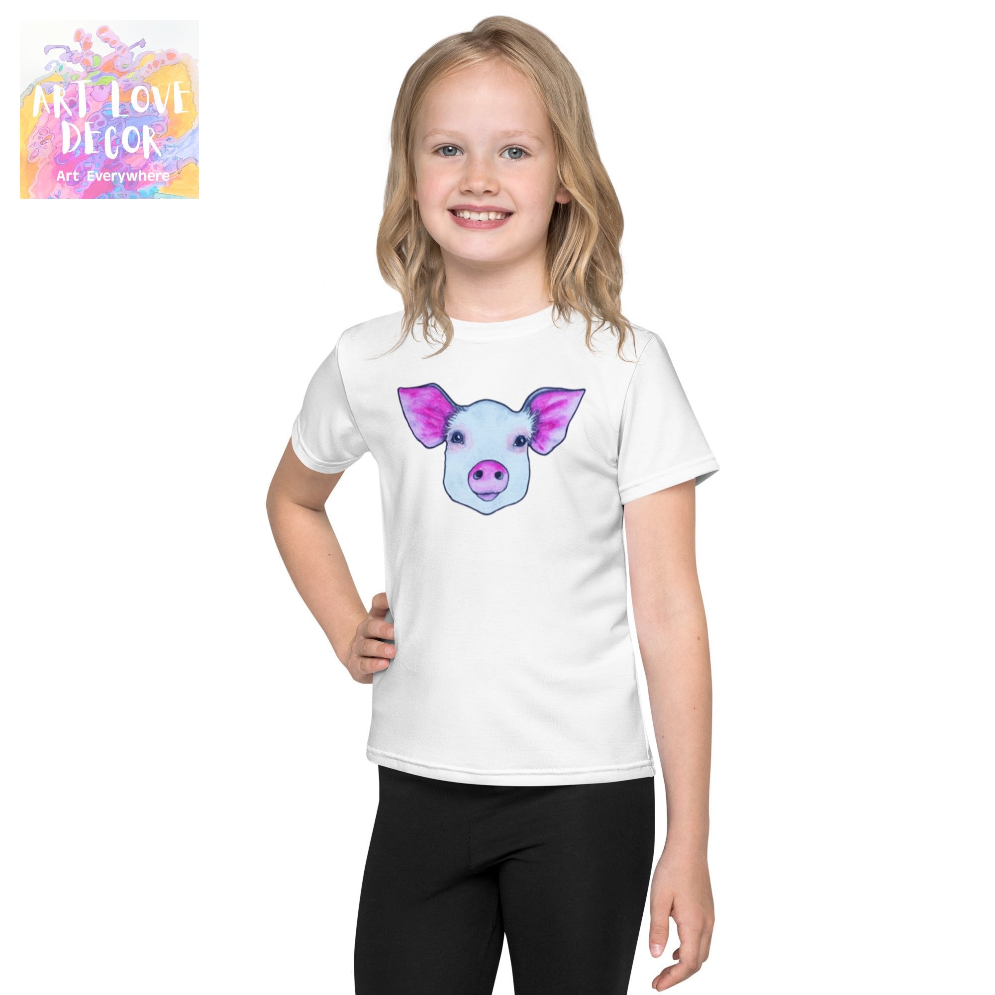 Child wearing white Piggy Kids T-shirt with colorful pig artwork by Joy Calonico
