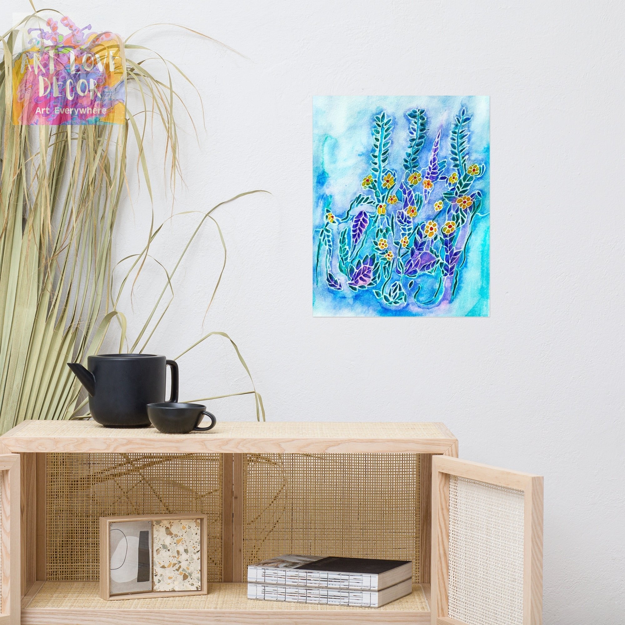 Frost Flowers Poster by Joy Calonico on white wall above wooden cabinet with black teapot and plants, vibrant floral artwork in blue and purple hues