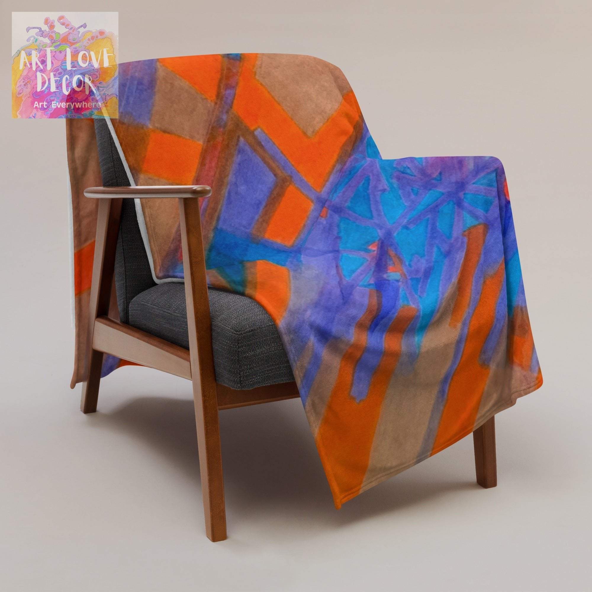 Hot Date Abstract Throw Blanket with vibrant orange, blue, and brown geometric design draped over wooden armchair