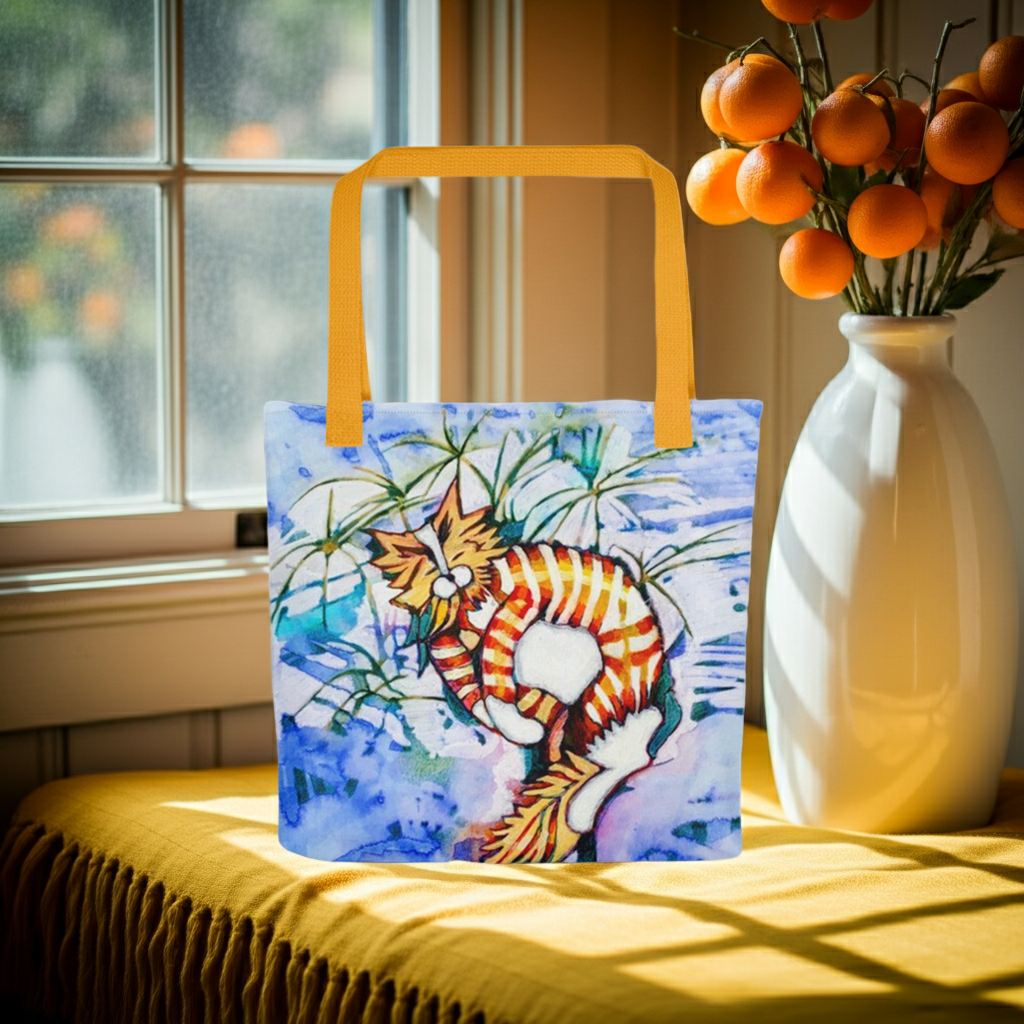 Orange Tabby Cat Tote bag with vibrant cat artwork and yellow handles on a window seat